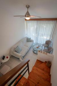 a living room with a white couch and a window at GreenWood Maisonette by RentalsPro - Fourka Beach Halkidiki in Fourka