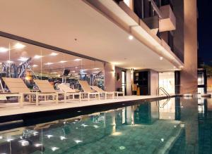 a swimming pool with lounge chairs next to a building at Aster Hotel and Residence by At Mind in Pattaya +100 photos