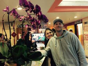 a man and a woman standing at a counter with flowers at Hong Kong Inn in Hong Kong