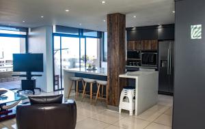 a kitchen with a bar with stools and a counter at No5 on Golden Sands in Margate