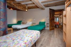 une chambre avec deux lits, une table et des chaises dans l'établissement Les hirondelles, à Saint-Maurice-de-Rotherens