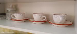 four cups and saucers sitting on a shelf at Near border in Narva