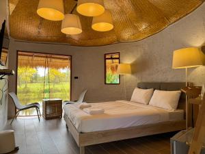 una camera da letto con un letto grande e una finestra di Khao Yai Lake Hill Resort a Khanong Phra