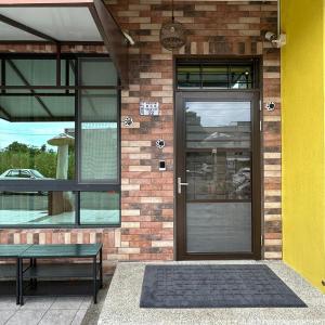 a house with a door and a bench in front of it at Yogurt Homestay in Taitung City
