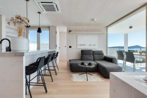 a kitchen and living room with a couch and a table at Sensus Aqua Villa Buqez in Drage