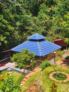 un padiglione blu con un tetto blu in un giardino di Forest and River Edge Resort a Kannur Altre 35 foto