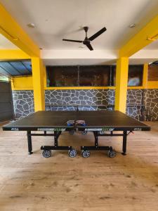 tavolo da ping pong in una stanza con soffitto di Forest and River Edge Resort a Kannur