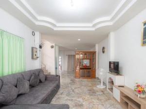 a living room with a couch and a television at Zaina Home Halal حل in Sathani Hat Yai