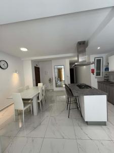 a kitchen and dining room with a table and chairs at Comfort 2BR Apartment near Beach & Café del Mar- By HostMT in St Paul's Bay