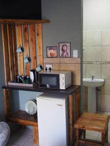a kitchen with a microwave on top of a refrigerator at Smirna Guesthouse in Vryburg