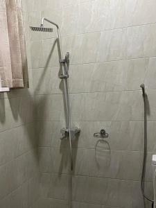 a shower with a glass door in a bathroom at Ritha Motel Apartment in Kigali +59 photos
