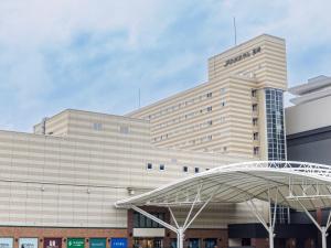un gran edificio con una señal que lee Amazonas en JR Kyushu Hotel Nagasaki, en Nagasaki