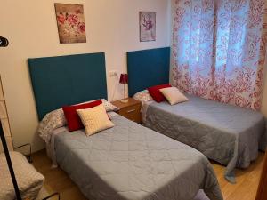 two beds in a room with blue and red at San Miguel in Membrilla