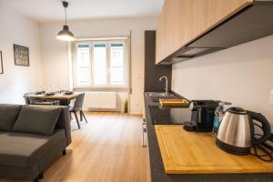 Una cocina y una sala de estar con un sofá y una mesa. en GetTheKey Marconi Apartments, en Bolonia