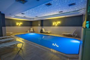 a swimming pool in a hotel room with chairs around it at The Green Park Taksim in Istanbul