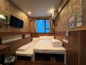 A bed or beds in a room at Hop Inn on Nathan Road