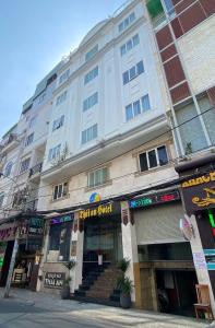 a large white building on a city street at Thái An Hotel Hồ Chí Minh in Ho Chi Minh City