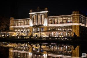 a large building with lights in front of it at night at Chios Lake Apartament in Cluj-Napoca