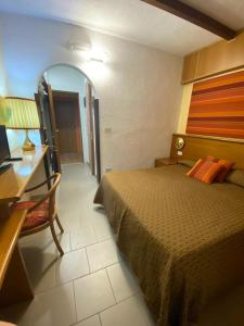 a hotel room with a bed and a desk and a table at Hotel Sila in Camigliatello Silano +44 photos