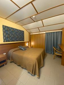 a bedroom with a bed and a table and a window at Hotel Sila in Camigliatello Silano