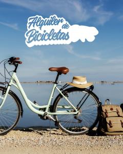 a bike with a hat sitting on the beach at Caseta de l'avi in Camarles