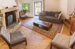 a living room with a couch and a fireplace at Domaine du Roc Gîtes 34 personnes in Campagnac-lès-Quercy