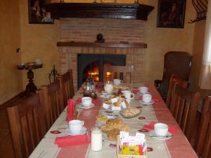 a table with food and a fireplace in a dining room at Señorío de Monterruiz in Casas de Santa Cruz