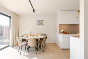 a kitchen and dining room with a table and chairs at Maison Nemo in Nieuwpoort