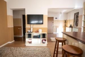 a living room with a kitchen with a tv on the wall at Chios Lake Apartament in Cluj-Napoca +3 photos