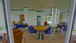 une salle à manger avec des chaises bleues et une table dans l'établissement Gorgora Eco Resort By Ethiopian Skylight, à Gorgora