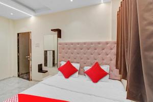 a bedroom with a large bed with red pillows at Hotel O S R Guest House in Sakardarā