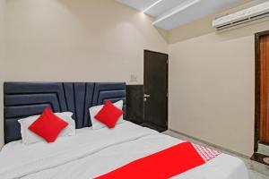 a bedroom with a large bed with red pillows at Hotel O S R Guest House in Sakardarā