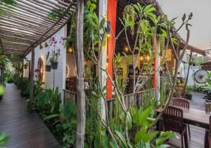 une terrasse couverte d'un restaurant avec un bouquet de plantes dans l'établissement Punleu Raksmey Boutique, à Phumĭ Ta Phŭl