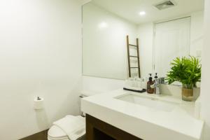 a white bathroom with a sink and a mirror at Palm Beach Resort in Biga +22 photos