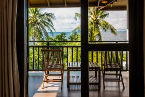 a balcony with two chairs and a table and a view of the ocean at Palm Beach Resort in Biga