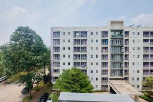 an apartment building with trees in front of it at Minimalist Studio Apartment (No Kitchen) at Aeropolis Residence By Travelio in Tangerang