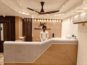 a man standing in a bathroom with a ceiling fan at Woodlands Inn in Chennai