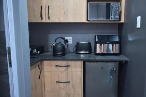 a kitchen with a counter top with a microwave and appliances at Hartklop Luxury Self Catering Guesthouse in Linkside