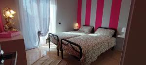 Un dormitorio con una cama y una pared rayada. en apartment sweet home, en Roma 10 fotos más