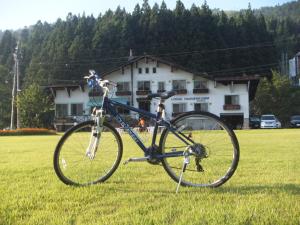 a bike parked in the grass in a field at Lodge Hahnenkamm in Nozawa Onsen