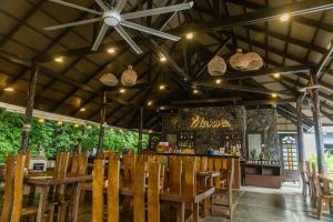 a restaurant with wooden tables and chairs and a bar at Palm Beach Resort in Biga