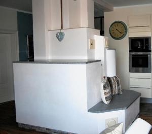 einen weißen Kühlschrank in einer Küche mit einer Uhr an der Wand in der Unterkunft Apartmany Villa Magnolie in Lipová-lázně