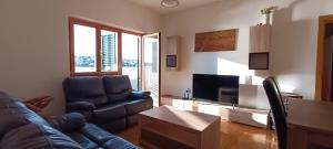 Una sala de estar con un sofá y un televisor. en Holliday house in Zatoglav, en Podglavica