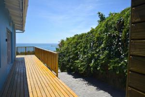 a wooden deck with a view of the ocean at Hartklop Luxury Self Catering Guesthouse in Linkside