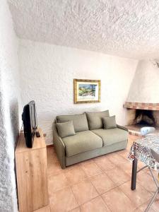a living room with a couch and a tv at Nura Bilo 2 in San Teodoro