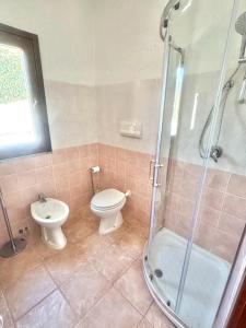 a bathroom with a toilet and a shower and a sink at Nura Bilo 2 in San Teodoro +8 photos
