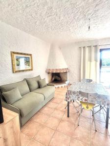 a living room with a couch and a table and a fireplace at Nura Bilo 2 in San Teodoro