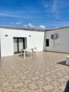 a patio with a table and a television on a white building at Nura Bilo 2 in San Teodoro