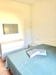 a bedroom with a blue bed with a window at Nura Bilo 2 in San Teodoro