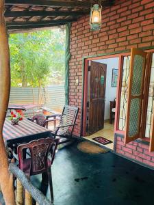 a patio with a table and chairs and a door at Sigiri Niwahana Home Stay in Sigiriya
